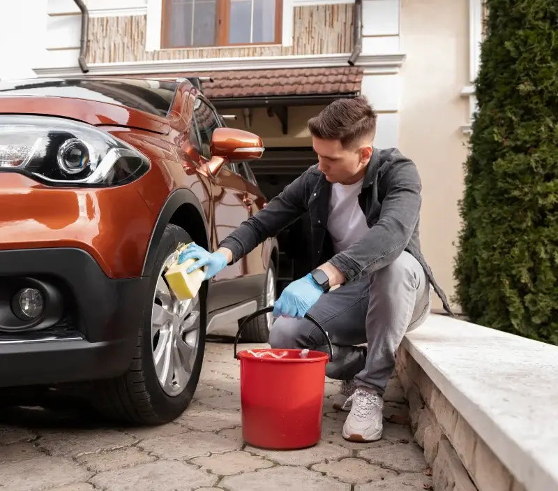 Lavage auto à domicile Neauphle-le-Château : professionnel intervenant sur un véhicule